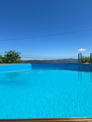 a large swimming pool with a blue sky in the background at Ti`Justina Country House in Rossas