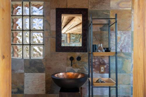 a bathroom with a bowl sink and a mirror at Earthship retreat + 2 spas + incredible views. in Santa Fe