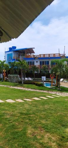 a building with palm trees in front of a park at La Rivera Playa Palomino in Palomino