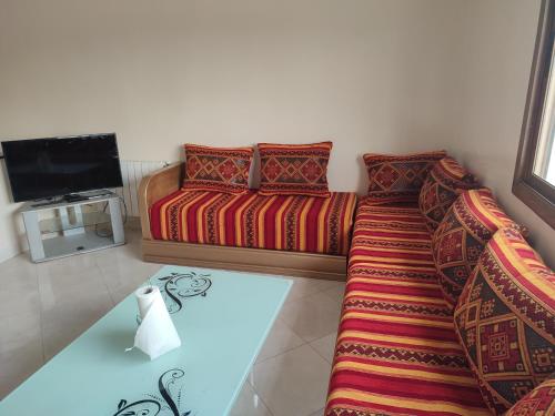 a living room with a couch and a tv at STOPOVER 1 MIDELT in Midelt