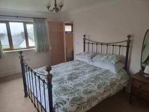 a bedroom with a large bed with a wooden frame at Criccieth Family holiday house in Morfa Bychan