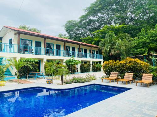 a villa with a swimming pool in front of a house at Hotel Diversion Tropical in Brasilito