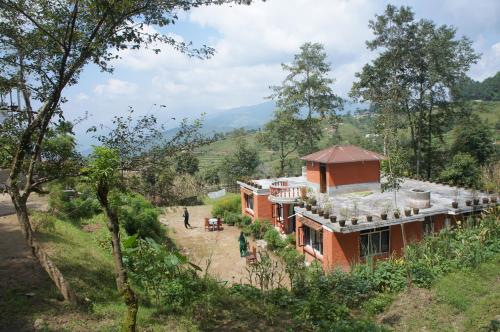 a house in the middle of a hill with trees at Hotel Mount Paradise in Nagarkot