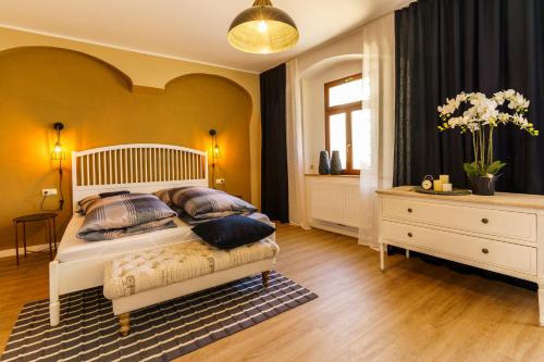 a bedroom with a bed with pillows and a dresser at Ferienwohnungen Stadtboutique in Annaberg-Buchholz