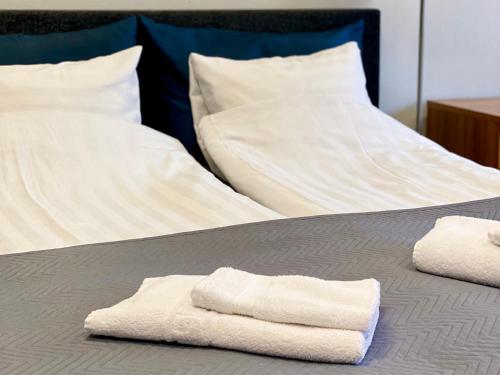dos toallas sentadas encima de una cama en City Apartment Kuopio, en Kuopio