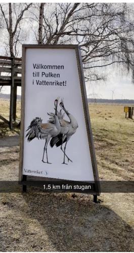 a sign with two birds on it in a field at Villa Sus & Dus in Yngsjö
