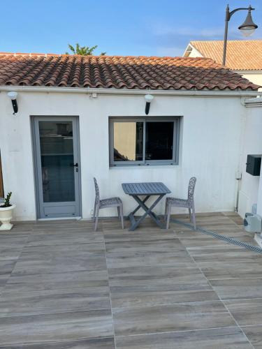 eine Terrasse mit 2 Stühlen und einem Tisch in der Unterkunft Studio La Rochelle - Rompsay in Périgny