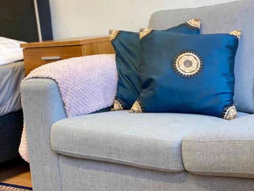 a blue couch with a pillow on top of it at City Apartment Kuopio in Kuopio