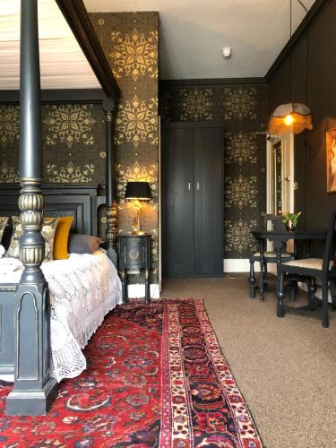 a bedroom with a bed and a red rug at The Clontarf in Llandudno