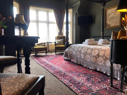 a bedroom with a bed and a grand piano at The Clontarf in Llandudno