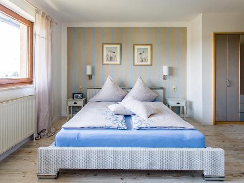 Un dormitorio con una cama azul con almohadas. en Gästehaus Chalet-Perle, en Bad Füssing