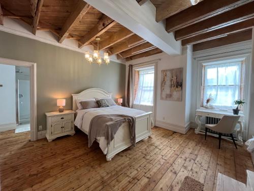 a bedroom with a bed and a chandelier at La Demeure du Capitaine in Neuville