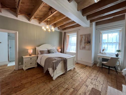 - une chambre avec un lit et un lustre dans l'établissement La Demeure du Capitaine, à Neuville