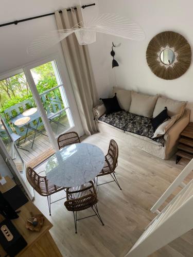 a living room with a table and chairs and a couch at villa blanche Cabine 1 in Cap-Ferret