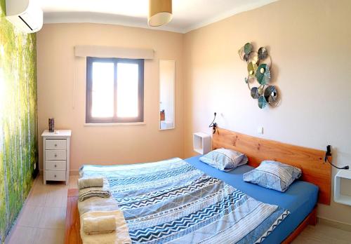 1 dormitorio con cama con sábanas azules y ventana en Miramar, en Carvoeiro