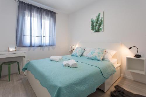 a bedroom with a bed with towels on it at Delminium in Kaštela