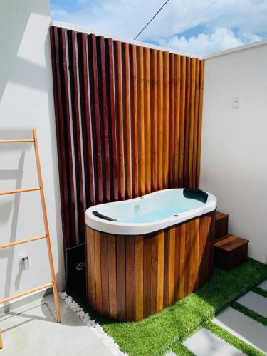 a bath tub in a room with a wooden fence at Meditarranee Residence in Camocim
