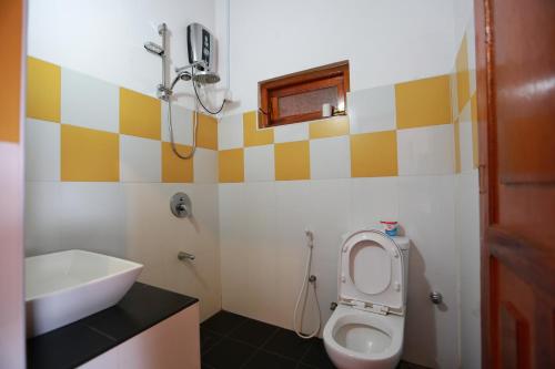 un baño con inodoro y lavabo en Tea Garden Holiday Inn, en Ella
