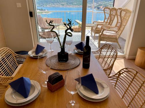 una mesa de madera con una botella de vino y copas en ViSun Apartment 2, en Vis