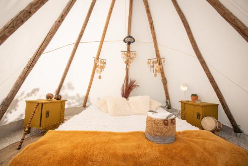 a bedroom with a bed in a tent at Slapen tussen de schapen in de Tante Tipi in Zennewijnen