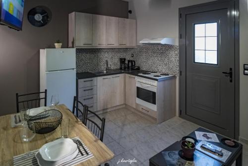 a kitchen with a table and a white refrigerator at Music Reflections Apartment near Nafplio in Nea Kios