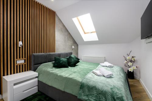 ダルウォボにあるApartamenty Magia Bałtykuのベッドルーム1室(緑のシーツと枕が備わるベッド1台付)