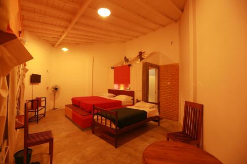 Una habitación con dos camas y un sofá en una habitación. en Tea Garden Holiday Inn, en Ella