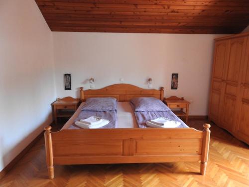 1 dormitorio con 1 cama de madera y 2 mesitas de noche en Guest House Vera, en Bled