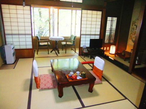 a living room with a table and chairs at Sumiyoshi Ryokan in Takayama