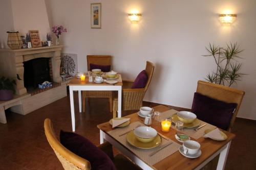 een eetkamer met een tafel en stoelen en een open haard bij Casa das Palmas in Óbidos