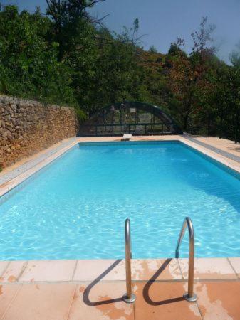 a large blue swimming pool with two metal handles at Chambre d'hôte Mas d'Alzon à St Jean du Pin in La Barriére