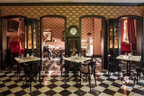 a restaurant with tables and a clock on the wall at Pałac Ciekocinko Hotel Resort & Wellness in Ciekocinko