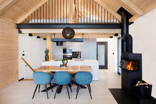 a kitchen and dining room with a wooden table and blue chairs at TRI VODY Demänovská Dolina in Liptovský Mikuláš