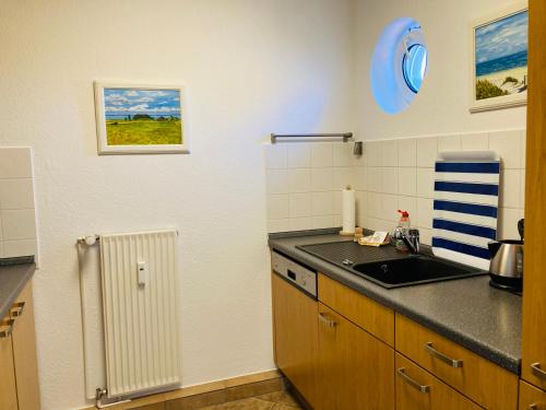 a kitchen with a sink and a counter top at FEWO VI Villa Nicole Hafenstraße 37 in Zingst