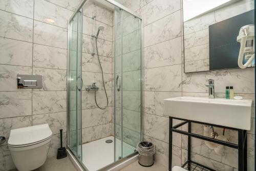 a bathroom with a shower and a toilet and a sink at Marmaris Kensington Green in Marmaris