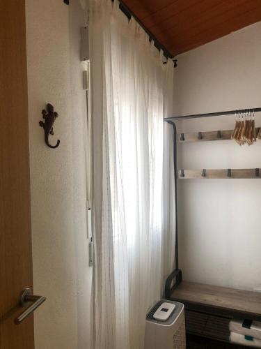 a bathroom with a white shower curtain and a toilet at Casa rural Leo&Manu in Benaoján