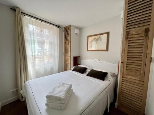 una camera da letto con un grande letto bianco e una finestra di Les Petits Volets 2 a Antibes