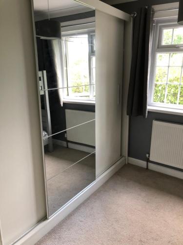 a mirror in a room with two windows at HALLSTEAD in Skegness