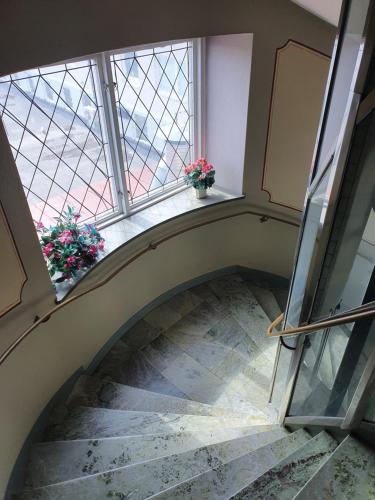 a stairway with two potted plants and a window at Saga Hotell in Borlänge