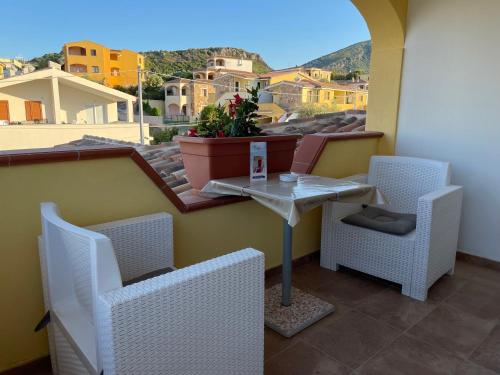 a table and chairs on a balcony with a view at Janas B&B in Posada