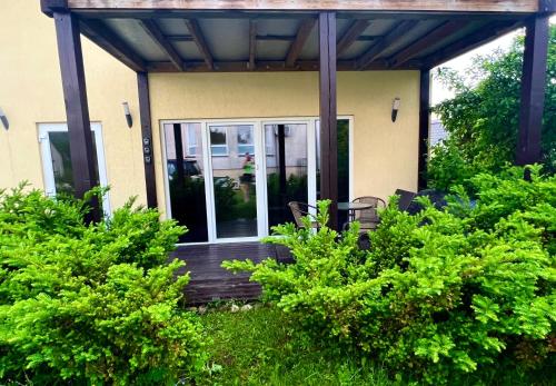 une terrasse couverte d'une maison avec des portes en verre dans l'établissement CENTRO Guest House, à Alytus