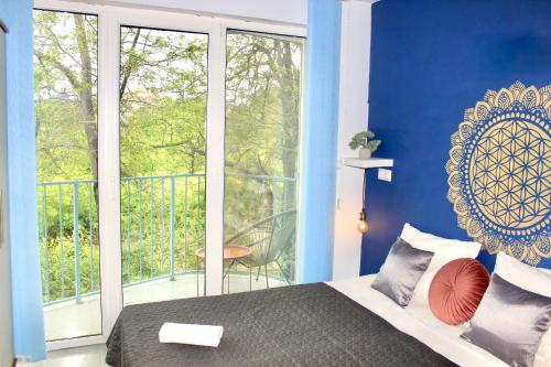 a bedroom with blue walls and a bed and a balcony at SUNSET ART Beach Front in Chernomorets