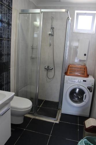a bathroom with a shower and a washing machine at Tebriz Apart in Kemer