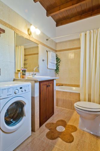 a bathroom with a washing machine and a toilet at ViLLA SYMONE in Afiartis