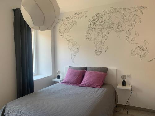 een slaapkamer met een bed met een wereldkaart aan de muur bij Au Paradis de la Rivière Joyeuse in Willer-sur-Thur