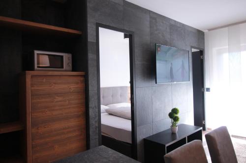 - une chambre avec un miroir, un lit et une télévision dans l'établissement CASA IBEX - Residence Veronza con piscina, Dolomiti Affitti, à Cavalese