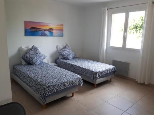 une chambre avec deux lits et une fenêtre dans l'établissement Villa Mer classée, à 3 mn à pied de la plage, à Frontignan