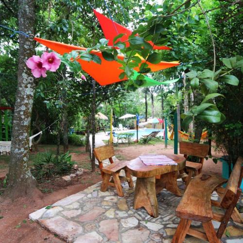 a picnic table and benches with an orange umbrella at Los Lapachos in Altos