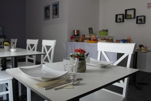 a white table with plates and utensils on it at Villa Žnjan in Split