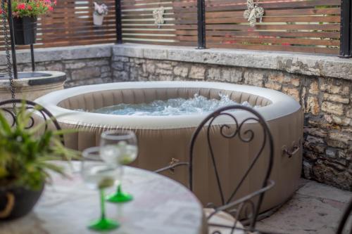 een hot tub met een tafel en een glas wijn bij Stara kuća in Heki